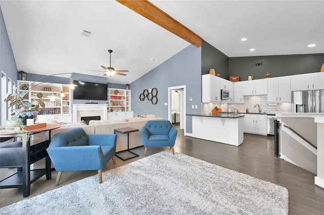 living area featuring ceiling fan, high vaulted ceiling, a fireplace, visible vents, and beam ceiling