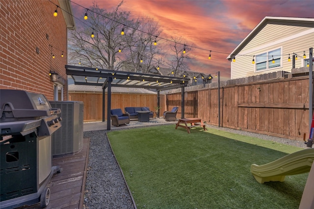 yard at dusk featuring a fenced backyard, cooling unit, an outdoor living space, and a pergola