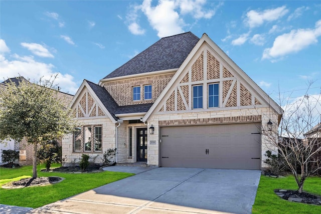 tudor-style house with driveway, stone siding, a front lawn, and roof with shingles