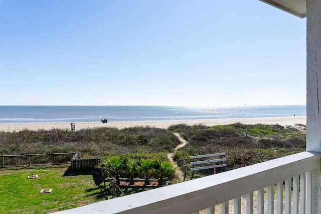 view of water feature featuring a beach view and fence