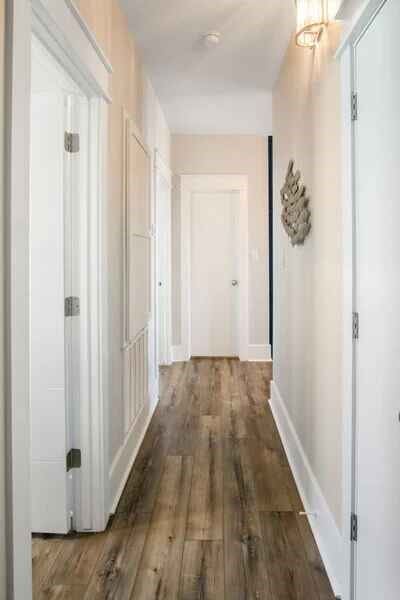 hall featuring wood finished floors and baseboards