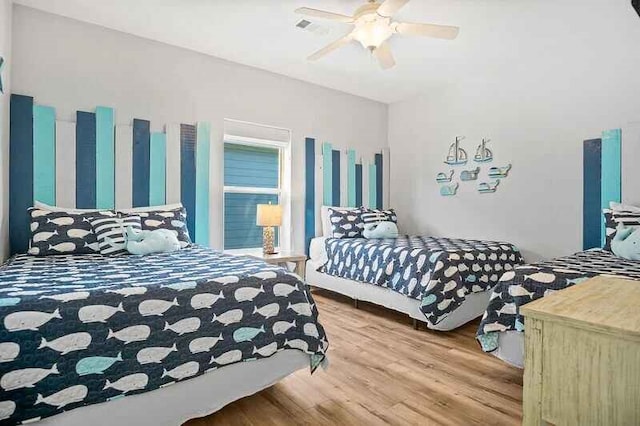 bedroom featuring ceiling fan, visible vents, and wood finished floors