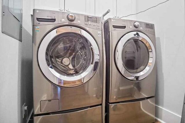 laundry area featuring washer and clothes dryer and cabinet space