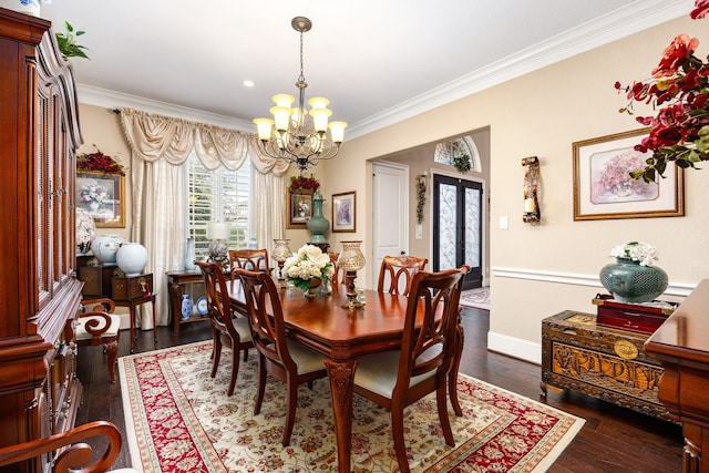 dining space with crown molding, dark wood-type flooring, a notable chandelier, and french doors