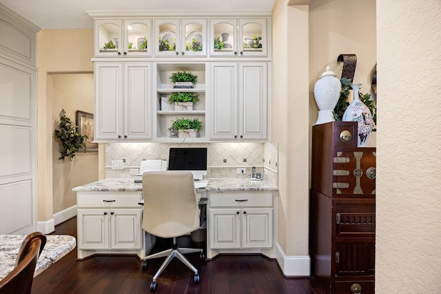 office with baseboards, dark wood-type flooring, and built in desk