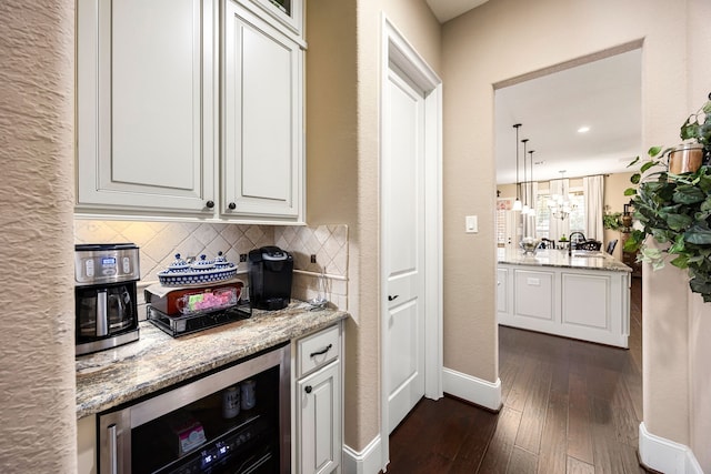 bar with baseboards, wine cooler, dark wood-style flooring, decorative light fixtures, and backsplash