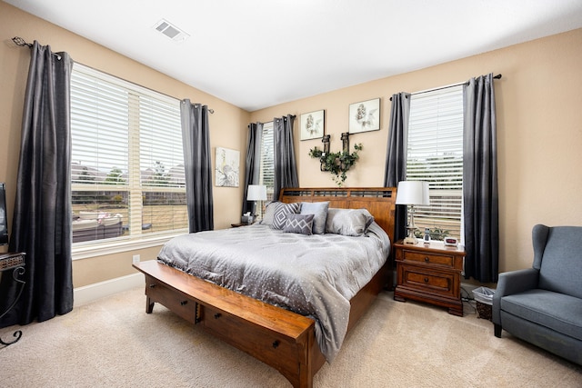 bedroom with light carpet, visible vents, and baseboards