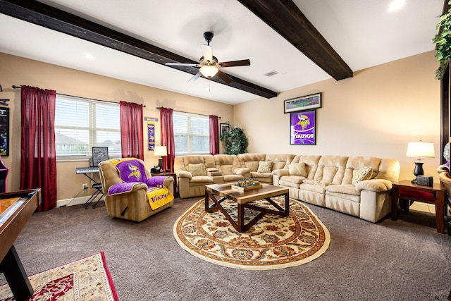 living room with ceiling fan, visible vents, baseboards, beamed ceiling, and dark carpet