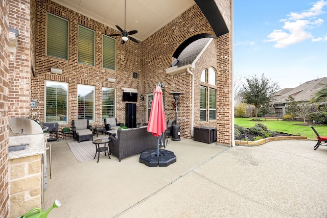 view of patio with an outdoor hangout area, an outdoor kitchen, fence, and a ceiling fan