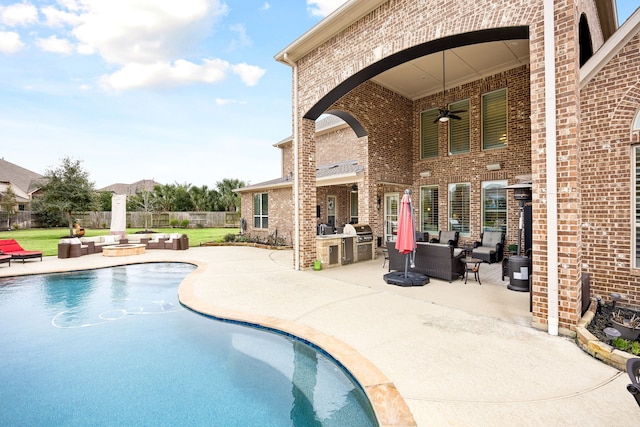 view of pool featuring a patio, an outdoor hangout area, a ceiling fan, exterior kitchen, and a fenced backyard