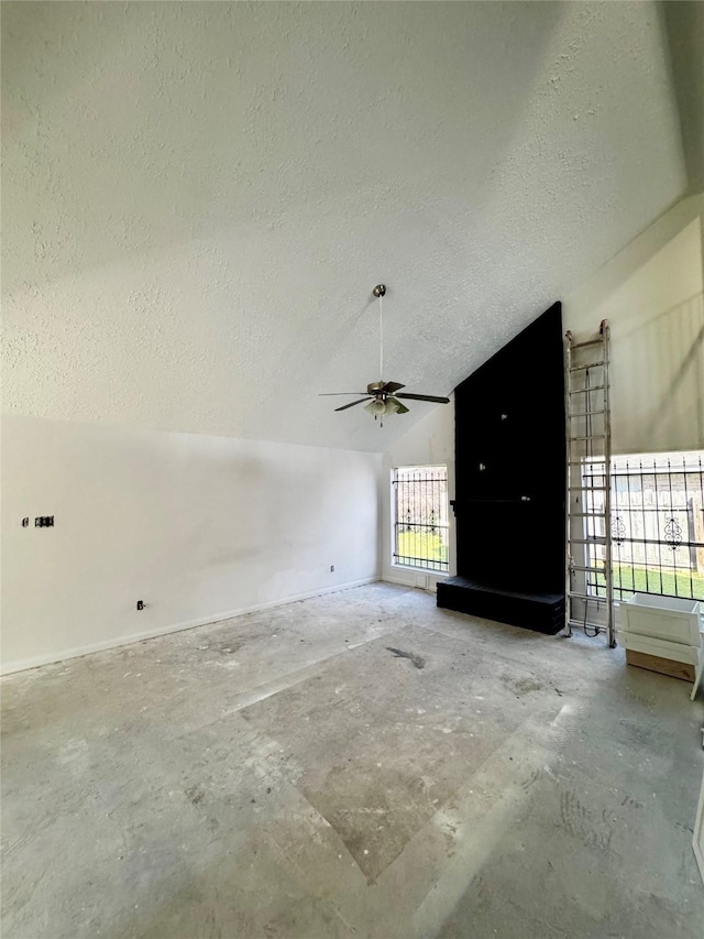 unfurnished living room with a ceiling fan, lofted ceiling, unfinished concrete flooring, and a textured ceiling