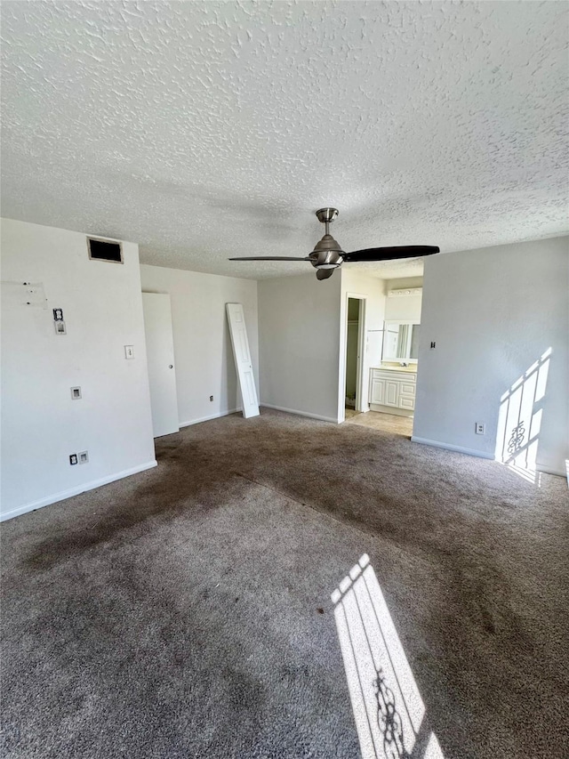 unfurnished living room with carpet, visible vents, ceiling fan, and a textured ceiling