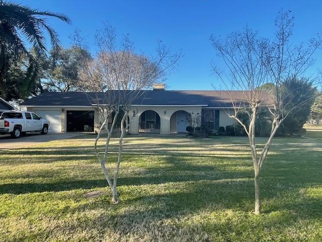 ranch-style house with driveway, a front lawn, and an attached garage