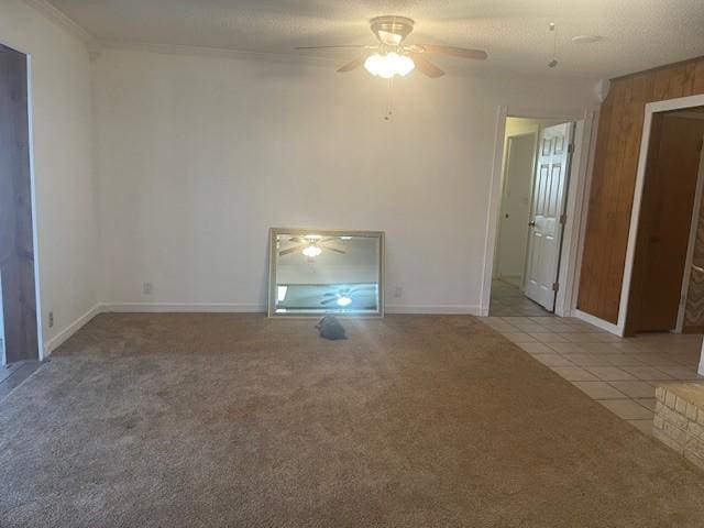 unfurnished living room featuring crown molding, light carpet, ceiling fan, a textured ceiling, and light tile patterned flooring