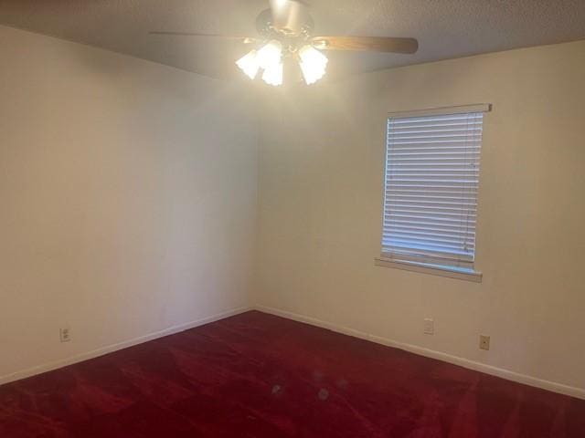 empty room with a ceiling fan, a textured ceiling, baseboards, and carpet flooring