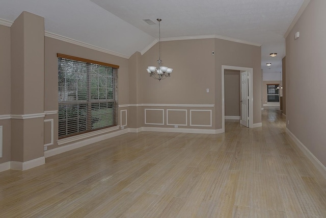 unfurnished room featuring a chandelier, light wood finished floors, lofted ceiling, and crown molding