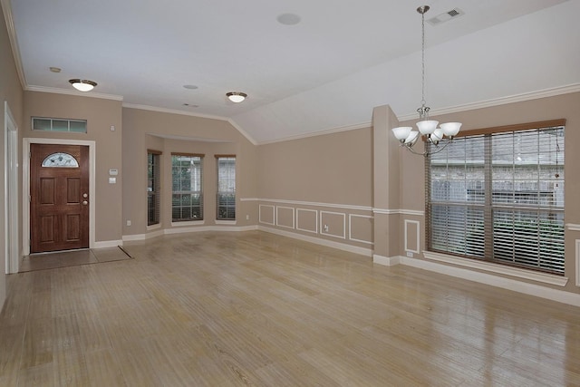 entryway featuring light wood-type flooring, visible vents, vaulted ceiling, and ornamental molding