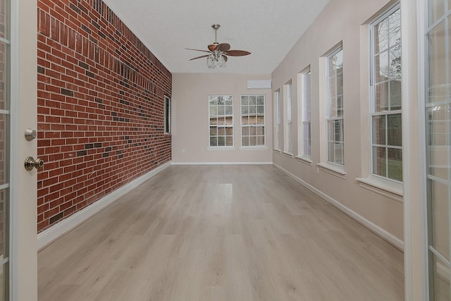 unfurnished sunroom with ceiling fan