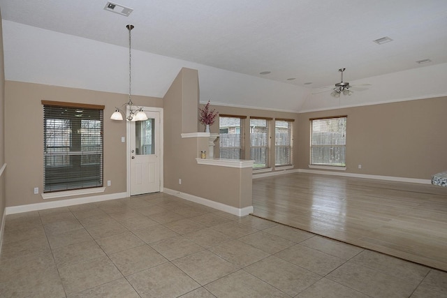 entrance foyer featuring light tile patterned floors, visible vents, vaulted ceiling, baseboards, and ceiling fan with notable chandelier