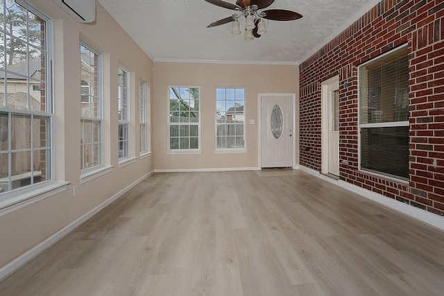 unfurnished sunroom featuring a ceiling fan and an AC wall unit