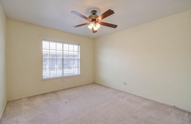 unfurnished room featuring light carpet, baseboards, and a ceiling fan