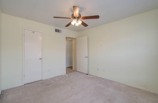 unfurnished bedroom with baseboards, visible vents, a ceiling fan, and light colored carpet