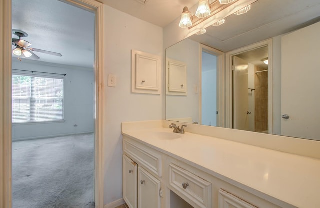 bathroom featuring ceiling fan, a shower, vanity, and baseboards