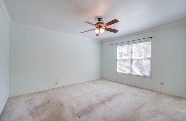 empty room with baseboards, crown molding, and light colored carpet