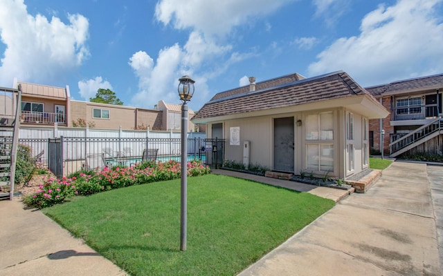 view of front of house featuring fence and a front lawn