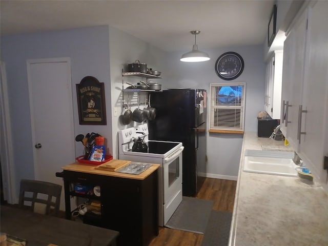 kitchen featuring dark wood-style flooring, a sink, baseboards, light countertops, and white electric range oven