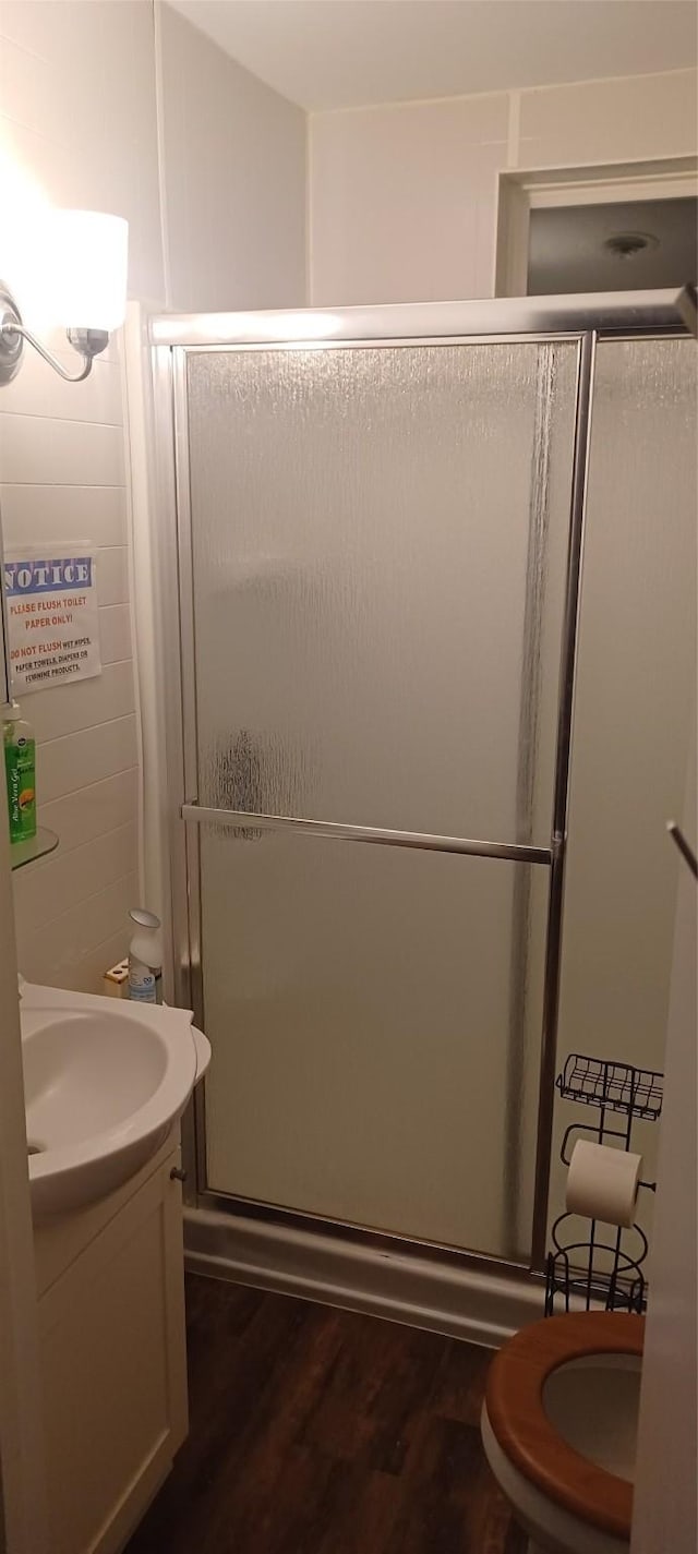 bathroom with a shower stall, wood finished floors, and vanity