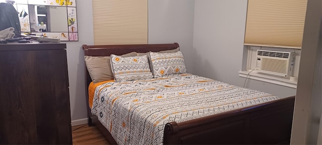 bedroom with cooling unit and wood finished floors