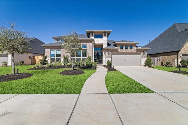 prairie-style house featuring a front yard, concrete driveway, brick siding, and an attached garage