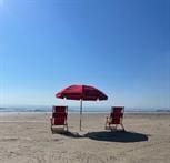 view of play area featuring a water view and a beach view