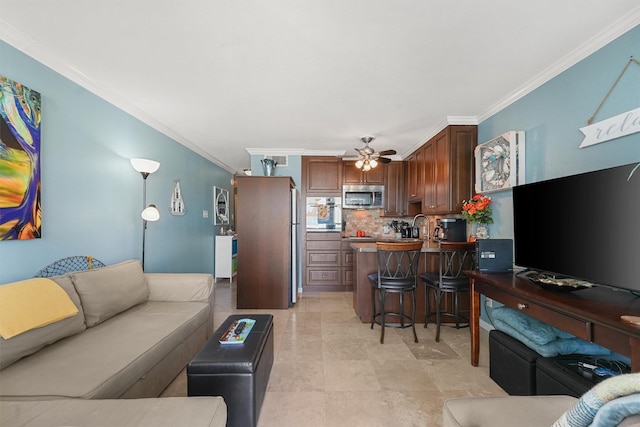 living area featuring a ceiling fan and crown molding