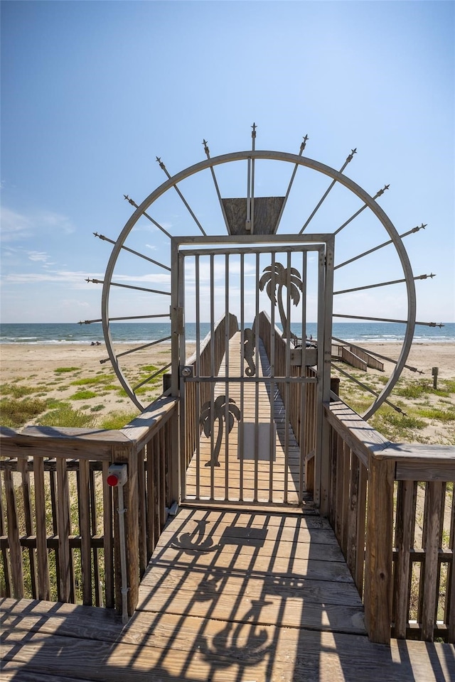 view of property's community with a water view and a beach view