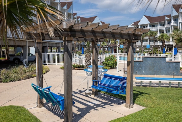 view of community with a lawn, fence, a pergola, and a patio