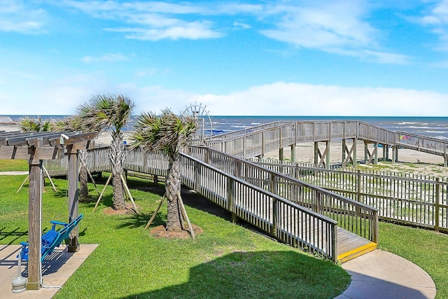 view of play area with a water view, a lawn, and fence