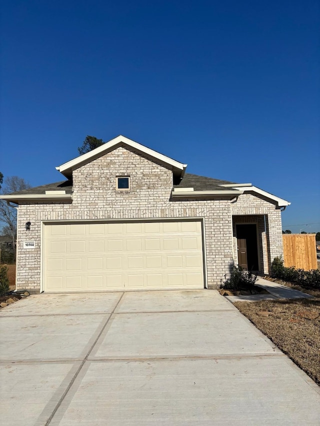 view of front of house featuring a garage, driveway, and brick siding