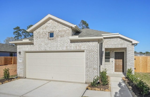 10702 Sora Dr, Willis, TX 77378 - view of front facade featuring brick siding, driveway, an attached garage, and fence
