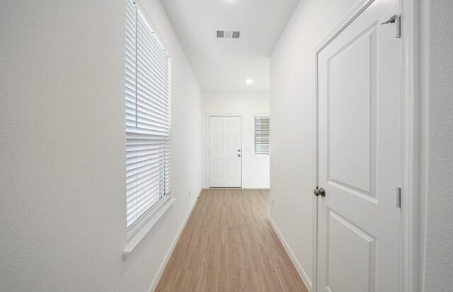 10702 Sora Dr, Willis, TX 77378 - hallway with light wood-style flooring, baseboards, and visible vents