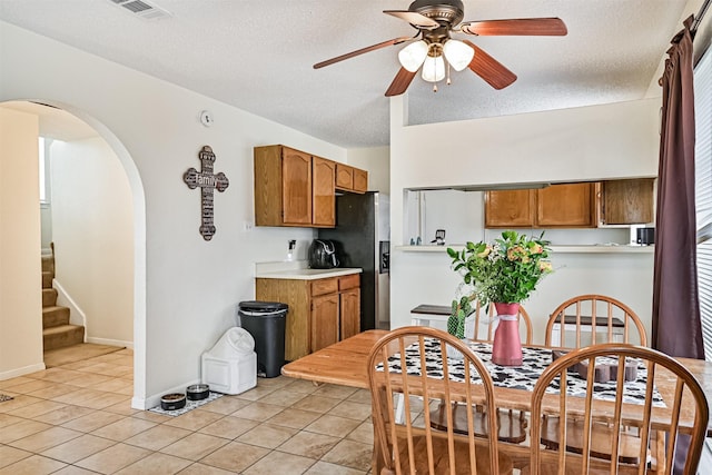 kitchen featuring visible vents, stainless steel fridge with ice dispenser, brown cabinets, light countertops, and light tile patterned flooring