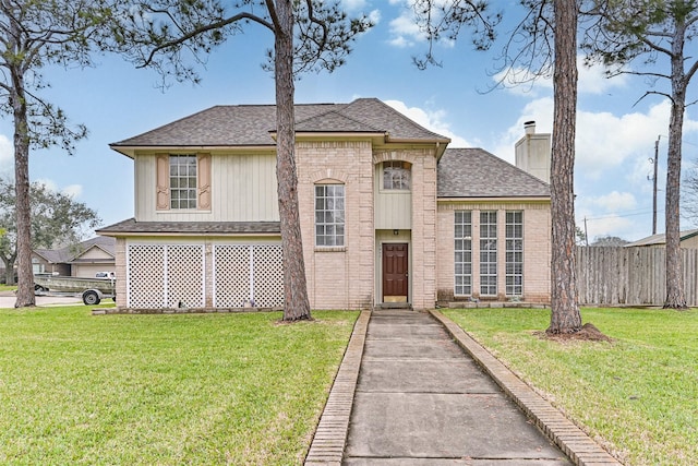 view of front of home with a chimney, fence, a front lawn, and brick siding