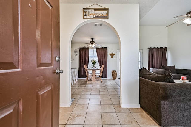 entryway with arched walkways, ceiling fan, and visible vents