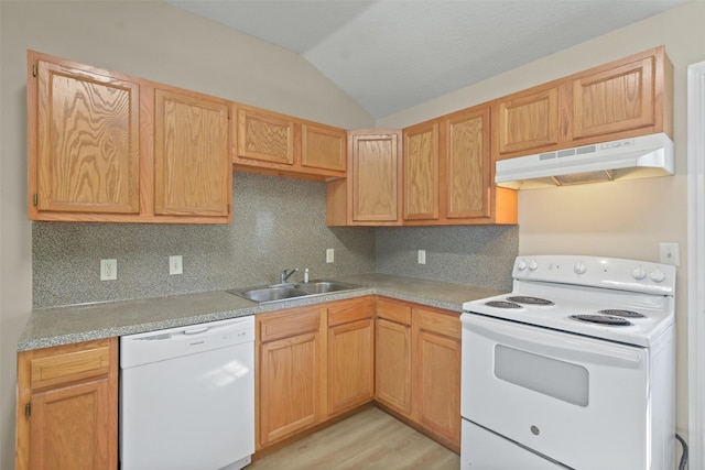 kitchen with white appliances, vaulted ceiling, light countertops, under cabinet range hood, and a sink