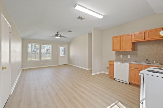 kitchen with white appliances, a sink, visible vents, open floor plan, and light countertops