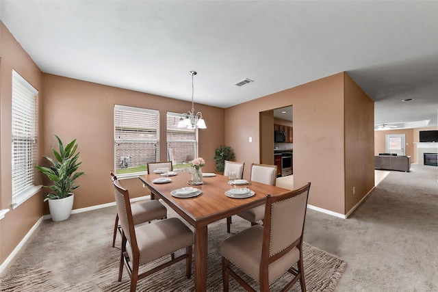 dining area with a healthy amount of sunlight, baseboards, visible vents, and light colored carpet