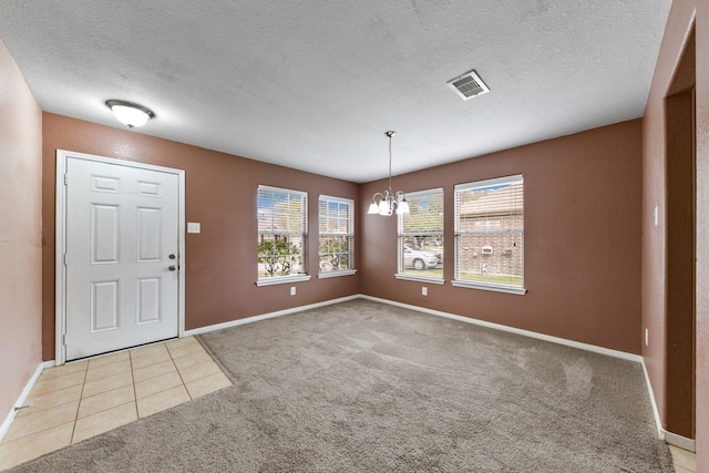 foyer entrance with light carpet, an inviting chandelier, plenty of natural light, and visible vents