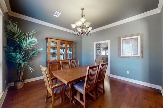 dining space featuring visible vents, baseboards, dark wood finished floors, ornamental molding, and a notable chandelier