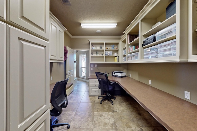 office with visible vents, ornamental molding, a textured ceiling, and built in study area